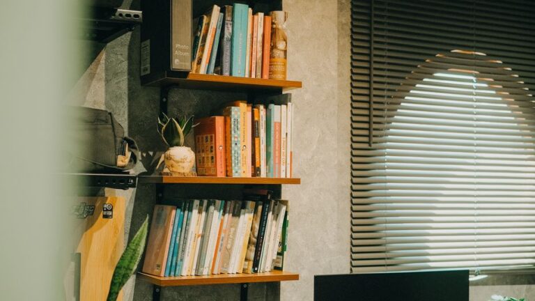 Bookshelf with various books in a well-lit home office, warm ambiance.