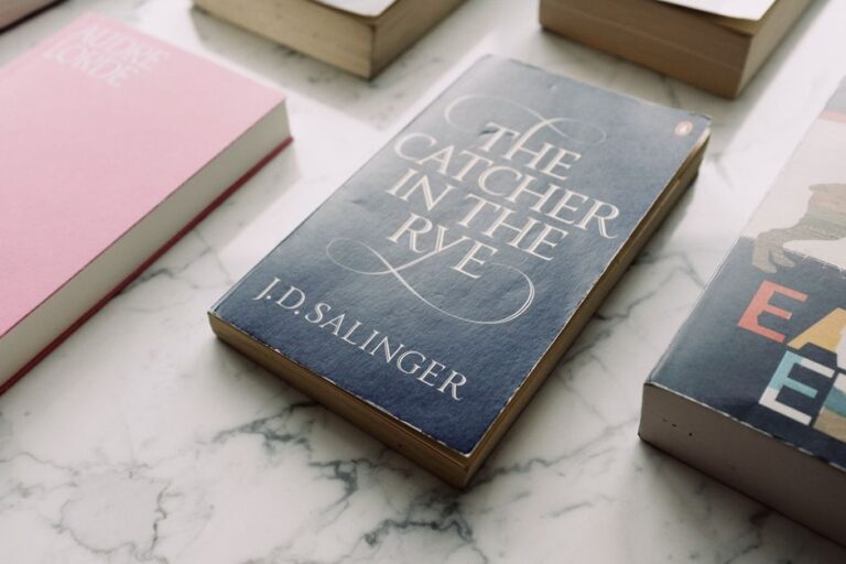 From above of famous novel paperback books with colorful covers arranged neatly on white marble table